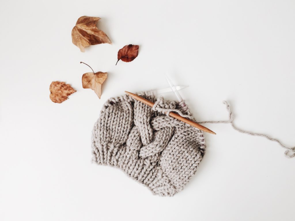 knitting a hat 3 needles with cable pattern in grey